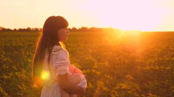 Pojem šťastné dětství. malá dcerka usne v náručí své matky v krásných paprsky slunce. šťastná rodina procházky při západu slunce v parku. šťastný rodinný koncept. Týmová práce. — Stock fotografie