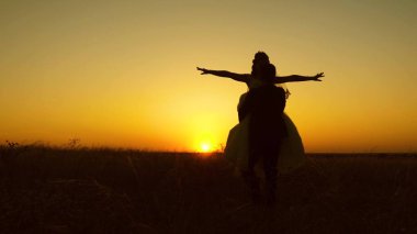 Genç gelin ve damat romantik kırmızı günbatımı arka plan üzerinde çember. Balayı. Erkek ve kadın arasındaki ilişki