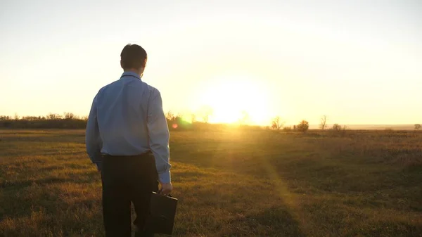 Hombre de negocios con maletín se enciende hermosa puesta de sol después del día de trabajo —  Fotos de Stock