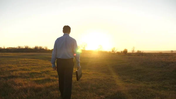 Geschäftsmann mit Aktentasche geht nach dem Arbeitstag in den schönen Sonnenuntergang — Stockfoto