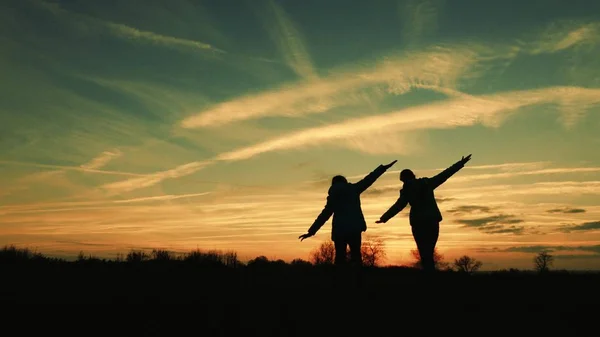 Children play in the evening at sunset. girls superheroes run across the meadow against the backdrop of beautiful sky. children dream of flying. concept of happy childhood. teamwork girlfriend — 图库照片