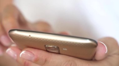 Kızlar el smartphone ekranında bir mobil ileti yazmakta olduğunu. Kadın el smartphone ve tarayıcı web sitesi ve e-posta tutun. yakın çekim.