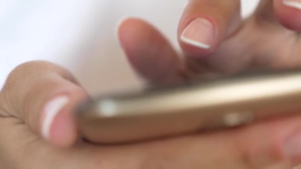 Frauenhände halten das Smartphone in der Hand und surfen Website und E-Mail. Nahaufnahme. eine Mädchenhand tippt eine mobile Nachricht auf den Smartphone-Bildschirm. — Stockvideo