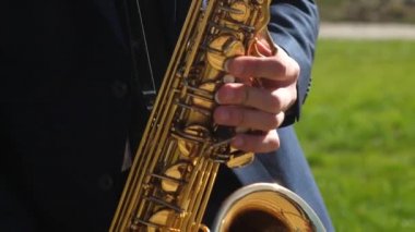 müzisyen Blues rüzgar enstrüman oynar. adam saksafon caz müziği oynuyor. Yemek ceketinde saksafoncu altın saksofon oynuyor. Canlı performans. Close