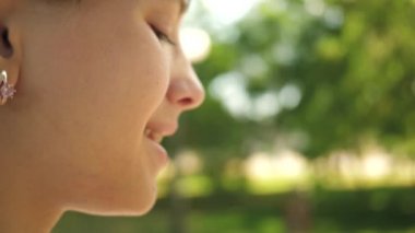 genç kız sabun köpüğü yakın çekim üfleme. Ağır çekim. İlkbahar, yaz ve gülümseyen içinde parkta sabun köpüğü üfleme güzel kız.