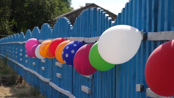 A cerca está decorada com balões. belo design das férias. Decoração festiva de umas férias de crianças com balões, casa de campo . — Vídeo de Stock