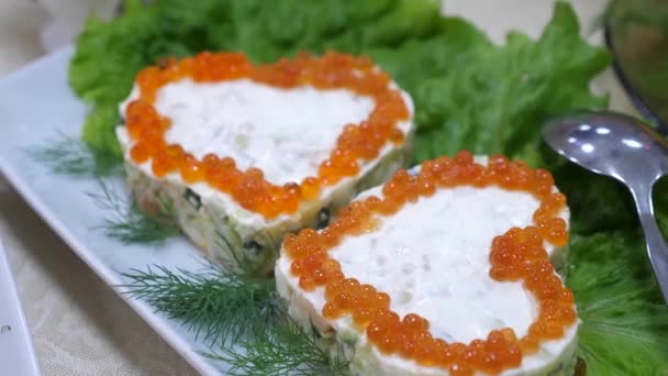 Sanduíches com caviar vermelho na forma de um coração e com endro em uma chapa e folhas de salada. mesa de jantar festiva. comida deliciosa na mesa . — Vídeo de Stock