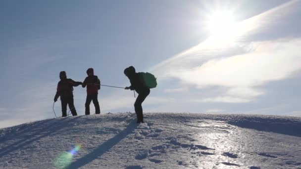 Alpenists team in winter down rope from mountain. Travelers descend by rope from a snowy hill. well-coordinated teamwork tourism in winter — Stock Video