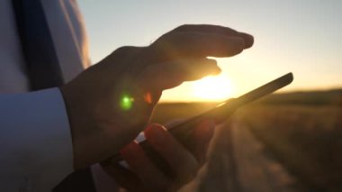 Günbatımında bir tablet üzerinde çalışan iş adamı. Ellerini bir adamın parmaklarını tablet üzerinde ilerliyorsunuz. yakın çekim. e-posta adam denetler.