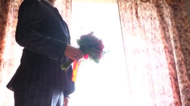 güzel çiçekler ile iş adamı. güzel bir kırmızı kravat ve beyaz gömlek ceketli adam elinde kırmızı gül buketi. yakın çekim.