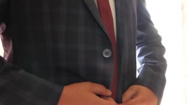 işadamı bir kafes içinde mavi bir ceket koyar. adam onun ceket düğmeleri düğmesi. ofis çalışanı sabah giyinmiş. Erkekler için şık ve modaya uygun giysiler kavramı