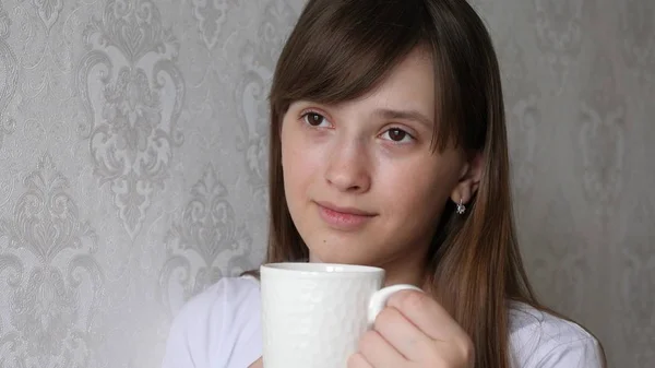 Красивая молодая женщина мечтает с чашкой горячего кофе . — стоковое фото