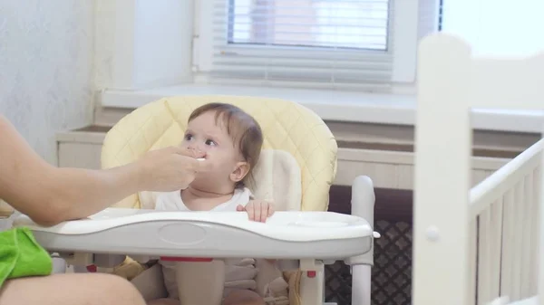 Baby is capricious and crying sitting on the highchair in kitchen. — Stock Photo, Image