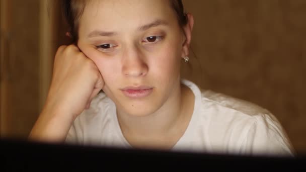 女の子は、夜のラップトップで電子ブックを読んでいます。子のコンピューターにおける社会的ネットワークに常駐し、電子メールをチェック — ストック動画