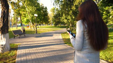 tablet hafif iş takım elbiseli kızla işe gidiyor. güzel iş kadını sokakta park tablet ile birlikte onun elinde yürür.