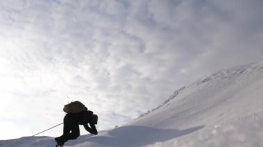 Üç Alpenists kışın dağda ipten in. Seyahat etmek güçlü bir rüzgar karda yokuş yukarı onların zafer halat tırmanmaya. turistlerin kışın birlikte zorluklar üstesinden takım çalışması.