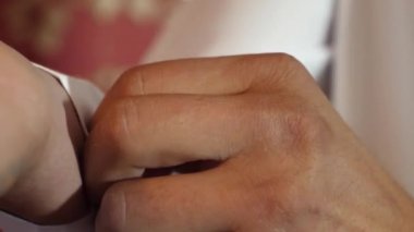 Erkekler bir düğme forması takılır. yakın çekim. işadamı beyaz forması koyar. moda adam kavramı