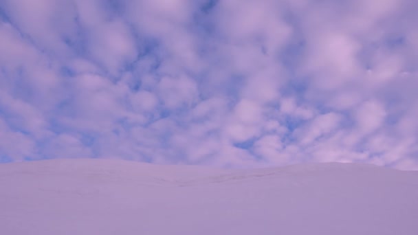 Güzel mavi gökyüzü günbatımı, pembe bulutlar güneş tarafından aydınlatılmış uçan gök yüksek. manzara karlı tepe ve kırmızı bulutlar. Şafak ya da karlı bir dağ üzerinde gündoğumu. — Stok video