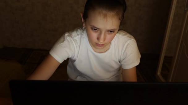 Chica adolescente cansado mira en la pantalla de un monitor portátil. Primer plano. Una joven mira a la pantalla del ordenador con los ojos cansados en su habitación por la noche. chica adolescente cansado mira en la pantalla de un monitor portátil . — Vídeos de Stock