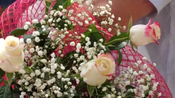 Bloemen als een geschenk voor vakantie. Close-up. Boeket in de handen van mannen van mooie bloemen en rode rozen. Close-up. — Stockvideo