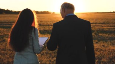 ekip çalışması erkekler ve kadınlar üzerinde bir iş projesi. siness toplantı erkek ve kadın parkta. Günbatımı ve gülmek işadamı ve işkadını tablet ile pazarlık.