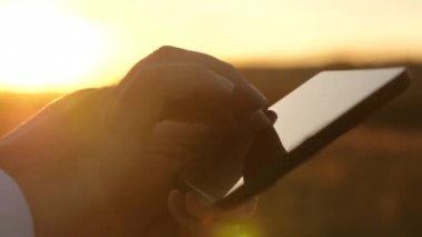 eller adamın parmaklarını tablet üzerinde ilerliyorsunuz. adam e-posta denetler. Tablet üzerinde günbatımında Park'ta çalışma iş adamı. Ziraat Mühendisi tablet alanında çalışır. Çiftçi ile bir çiftlikte