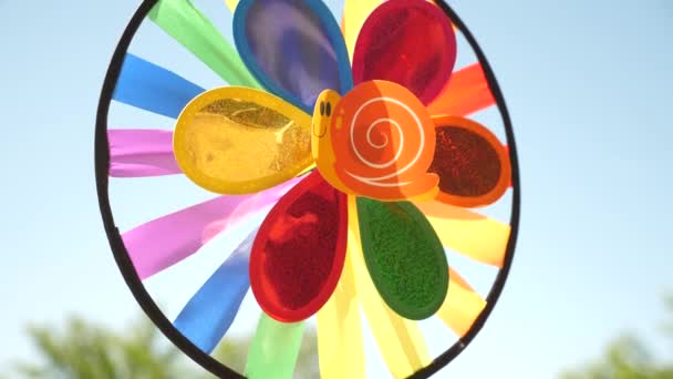 Spielzeug Windrad bunt, vom Wind gegen einen blauen Himmel gedreht. Bunte Dekorationen für ein Kinderfest. Konzept eines schönen Urlaubs. — Stockvideo