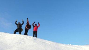 Yolcuları karlı bir tepenin üstüne gelin ve mavi gökyüzü karşı zafer keyfini çıkarın. Takım çalışması ve zafer. Takım çalışması zor koşullarda insan. turistlerin kışın karda seyahat.