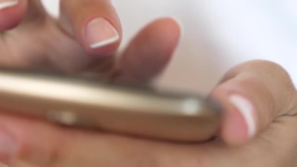 Mãos das mulheres segurar o smartphone e navegador do site e e-mail. close-up. Uma mão de meninas está digitando uma mensagem móvel na tela do smartphone . — Vídeo de Stock