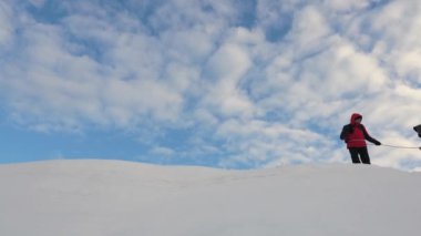dağcı kar sırtı boyunca birbirlerini takip, yolcular halat ile bağlı. turistler dağın tepesine çıkar. koordineli takım çalışması, kışın turizm. zafere git.