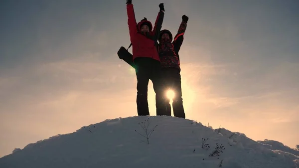 Teamarbeit und Sieg. Touristen reichen einem Freund die Hand, der auf den Gipfel des Hügels steigt. Bergsteiger im Winter auf verschneiten Bergen arbeiten in Kamanda, um einen Hügel zu erklimmen. Sporttourismuskonzept. — Stockfoto
