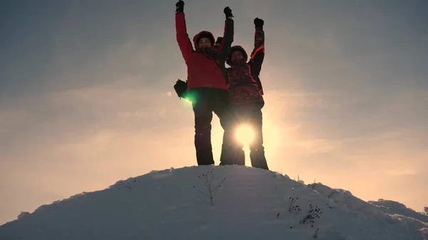 Trabajo en equipo y victoria. Los turistas se extiende la mano a amigo que se eleva a la cima de la colina. Los escaladores en invierno en las montañas nevadas trabajan en Kamanda ayudando a subir una colina. concepto de turismo deportivo . —  Fotos de Stock