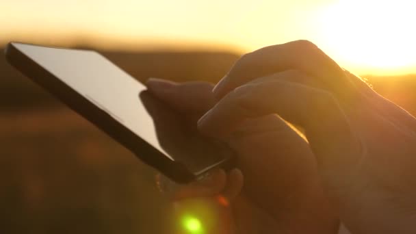 Manos del hombre están conduciendo sus dedos sobre la tableta. hombre comprueba correo electrónico. Empresario trabajando en tableta al atardecer en el parque. agrónomo trabaja con la tableta en el campo. agricultor en plantación con — Vídeo de stock