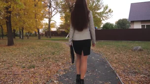 Szexi üzleti nő hordozza a kezében egy fekete táskát a dokumentumokat. a sikeres üzletasszony koncepcióját. nő egy öltöny egy fekete táskát a kezében sétál egy városi parkban. — Stock videók