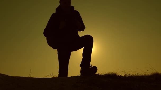 Le travail d'équipe des gens d'affaires. les voyageurs montent la colline dans les rayons du soleil un par un. Au ralenti. touristes voyagent avec des sacs à dos. L'équipe d'affaires est pressée de gagner et de réussir . — Video