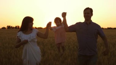anne ve baba olgun buğday bir alan etrafında seyahat ile mutlu kızı, çocuk gülüyor. aile takım çalışması. Anne ve babası ile bebek oynarken ve buğday ile alanda gülümseyerek. mutlu aile ve çocukluk kavramı
