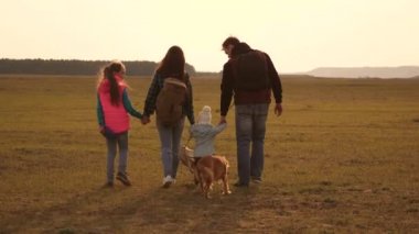 Baba, anne, kızları ve evcil hayvanları, turistler. birbirine sıkı sıkıya bağlı bir ailenin takım çalışması. aile, köpekle birlikte ovaları ve dağları dolaşır. Doğada bir spor aile tatili kavramı.