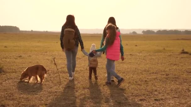 Aile, köpekle birlikte ovaları ve dağları dolaşır. anne, kız ve ev evcil hayvan turistler. birbirine sıkı sıkıya bağlı bir ailenin takım çalışması. Doğada bir spor aile tatili kavramı. — Stok video