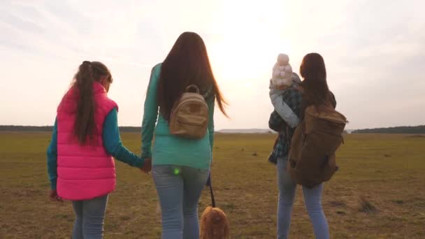 Mãe, criança e filhas e animais de estimação turistas. a família viaja com o cão na planície. trabalho de equipa de uma família unida. O conceito de umas férias de família de esportes na natureza . — Vídeo de Stock