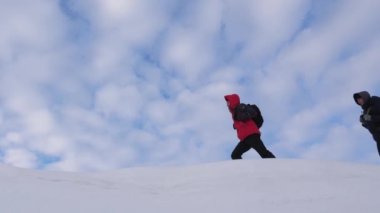 Gezginler karlı sırt boyunca birbirlerini takip ediyorlar. kışın iyi koordine takım çalışması turizm. zor koşullarda takım çalışması insanlar. kışın dağcılar ekibi dağın tepesine gitmek.