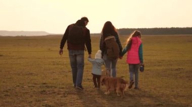 aile, köpekle birlikte ovaları ve dağları dolaşır. Baba, anne, kızları ve evcil hayvanları, turistler. birbirine sıkı sıkıya bağlı bir ailenin takım çalışması. Doğada bir spor aile tatili kavramı.