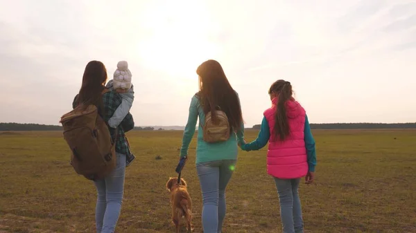 Familie reist met de hond op de vlakte. teamwork van een hechte familie. moeder, kleine kind en dochters en huisdieren toeristen. Het concept van een sportieve familie vakantie in de natuur. — Stockfoto