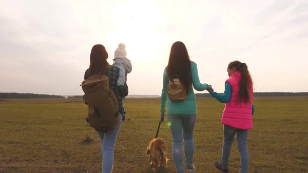 Familie reist met de hond op de vlakte. teamwork van een hechte familie. moeder, kleine kind en dochters en huisdieren toeristen. Het concept van een sportieve familie vakantie in de natuur. — Stockfoto