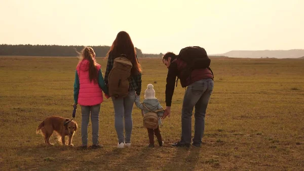 Papa, Mama, Töchter und Haustiere, Touristen. Teamwork einer engen Familie. Die Familie reist mit dem Hund durch die Ebenen und Berge. das Konzept eines sportlichen Familienurlaubs in der Natur. — Stockfoto