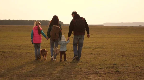 Baba, anne, kızları ve evcil hayvanları, turistler. birbirine sıkı sıkıya bağlı bir ailenin takım çalışması. aile, köpekle birlikte ovaları ve dağları dolaşır. Doğada bir spor aile tatili kavramı.