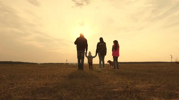 Papa, Mama, ein kleines Kind und Töchter und Haustiere Touristen. Teamwork einer engen Familie. Familie ist mit Hund in der Ebene unterwegs. das Konzept eines sportlichen Familienurlaubs in der Natur. — Stockfoto