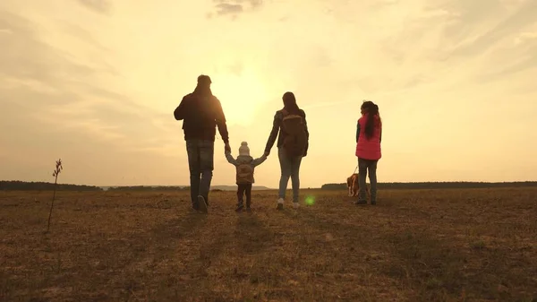 Papa, Mama, ein kleines Kind und Töchter und Haustiere Touristen. Teamwork einer engen Familie. Familie ist mit Hund in der Ebene unterwegs. das Konzept eines sportlichen Familienurlaubs in der Natur. — Stockfoto