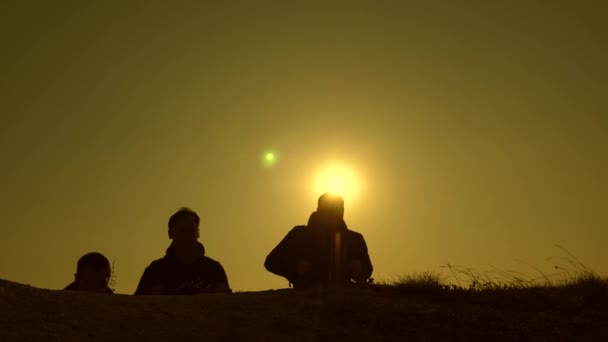 Les voyageurs montent la colline dans les rayons du soleil un par un. touristes voyagent avec des sacs à dos. le travail d'équipe des gens d'affaires. Mouvement lent.L'équipe d'affaires est pressée de gagner et de réussir . — Video