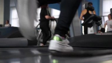 güçlendirilmesi bacak kasları çalıştırın. koşu bandı yakın çekim üzerinde spor ayakkabı kız bacakları. spor salonunda yürümek. kardiyo yük. Kız koşu bandında antrenman lar. fitness kulübü kadın. spor salonunda kilo kaybı.