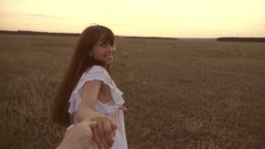 kız sevgili adamın elini tutarak alan boyunca çalışır ve gülüyor. Yavaş çekim. aşk çift mutlu el ele çalışır. mutlu bir aile kavramı. kız ve adam şehir dışında seyahat.